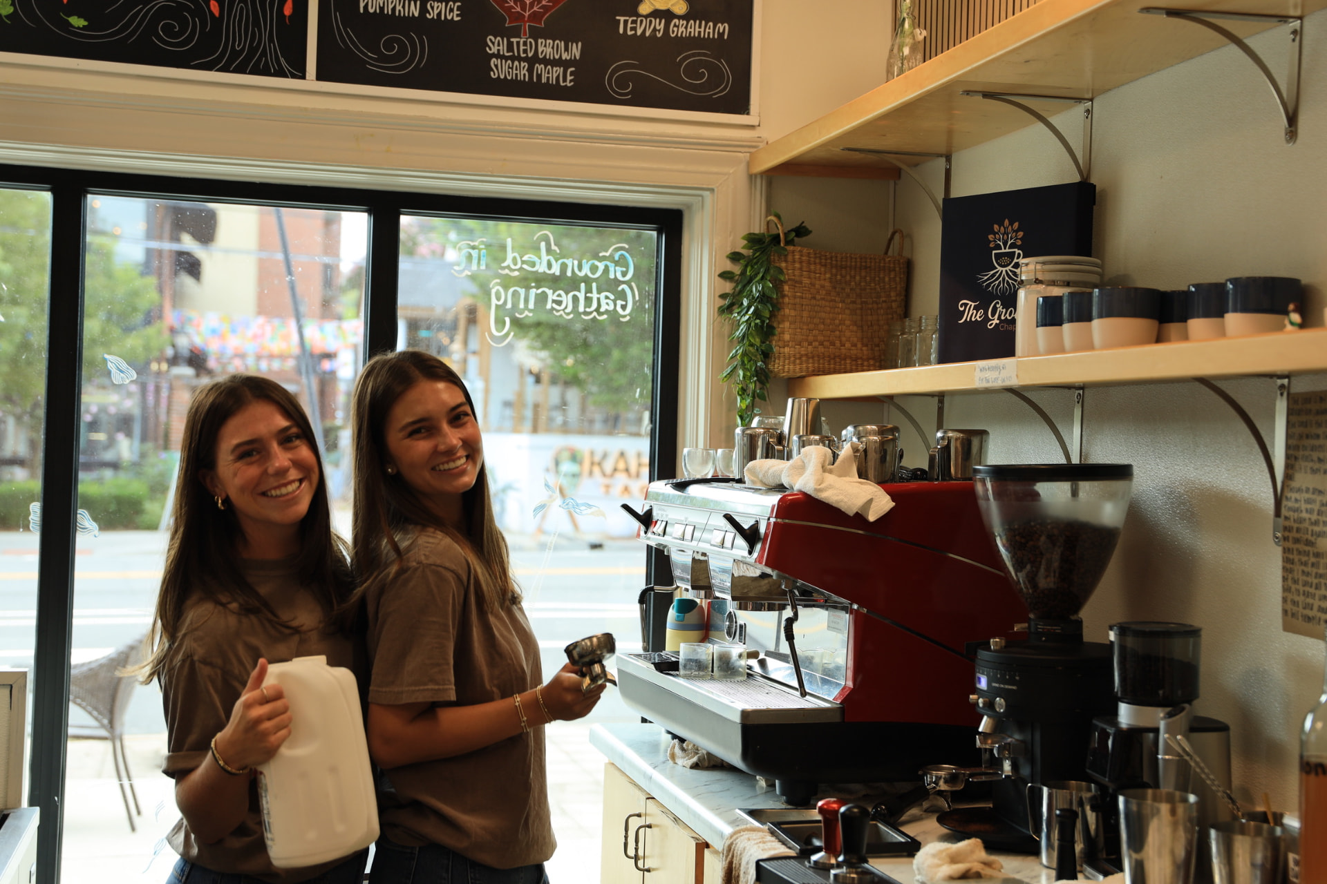 Two of The Grounds founders in white Grounds tees behind the espresso machine